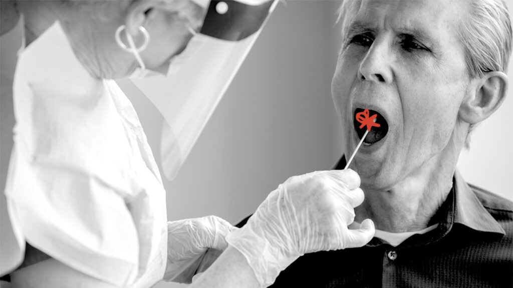 black and white photo of doctor in full protective gear taking cheek swab sample from older male patient