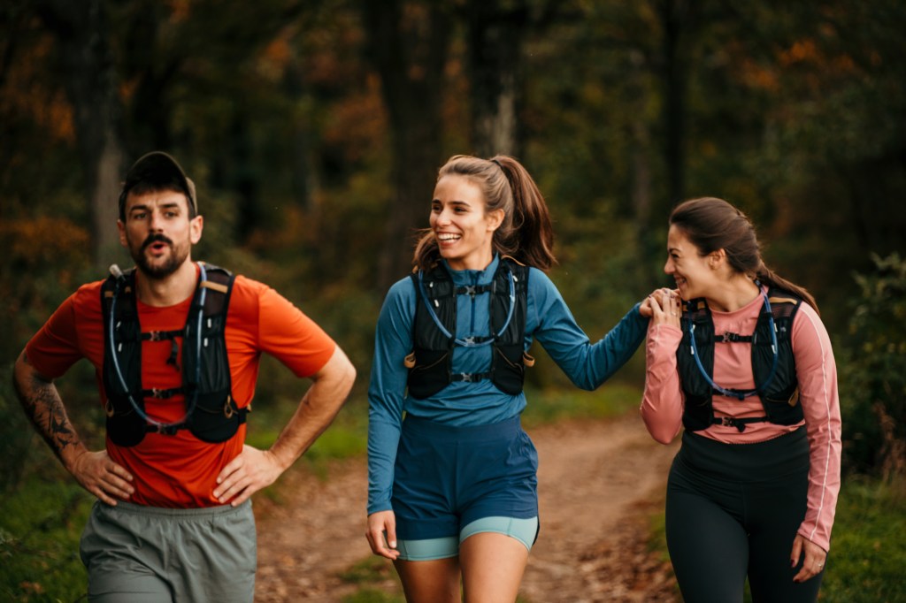 Young male and female joggers resting after a run in the forest