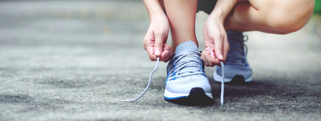 Closeup of a person lacing up a sneaker.