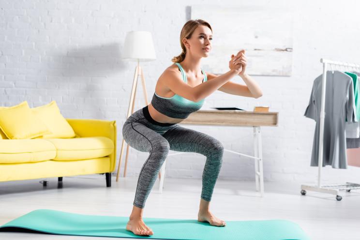 Woman doing squats while barefoot.