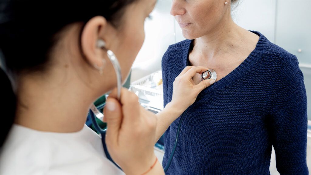 female doctor auscultating female patient