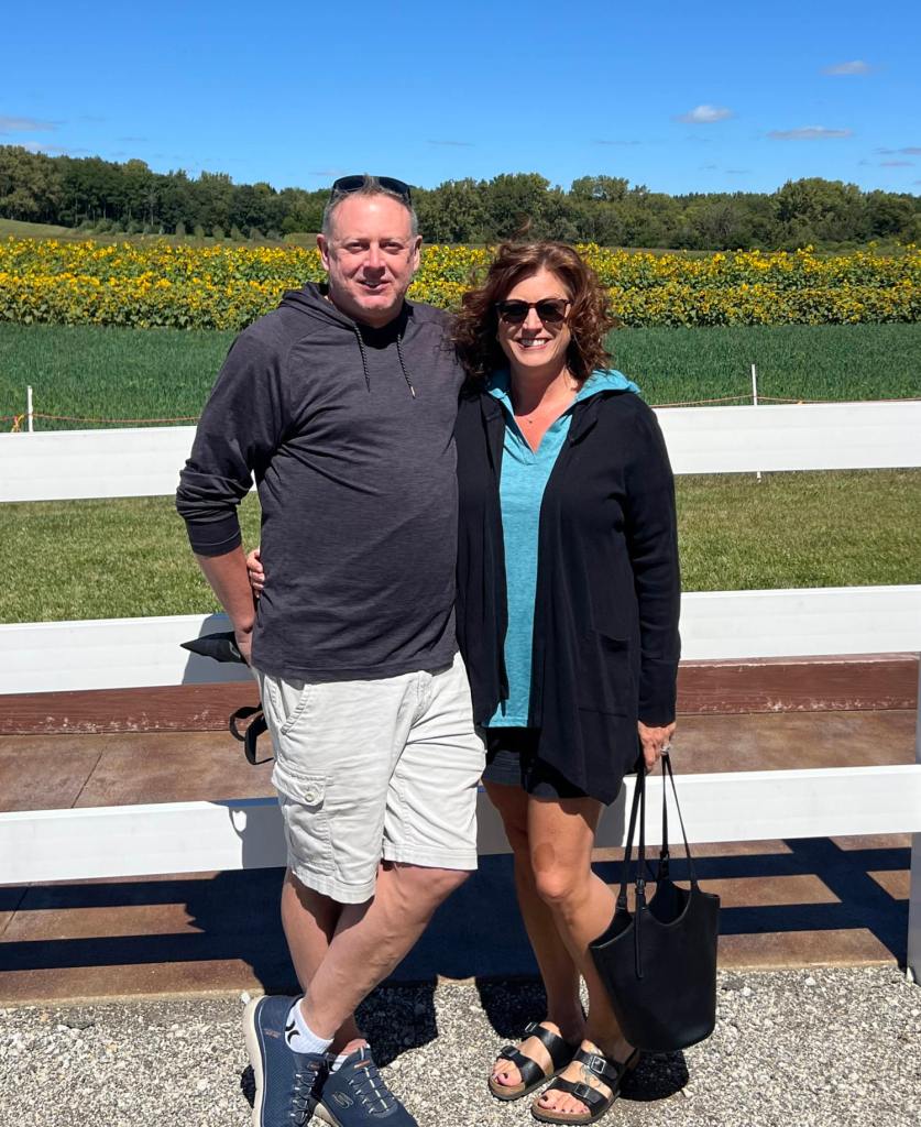 Lori Jerisha, 47, looking healthier standing in a field of flowers after losing weight through walking and diet changes