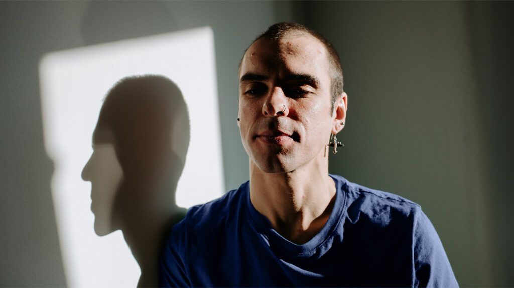 A person's profile and shadow reflected on a wall