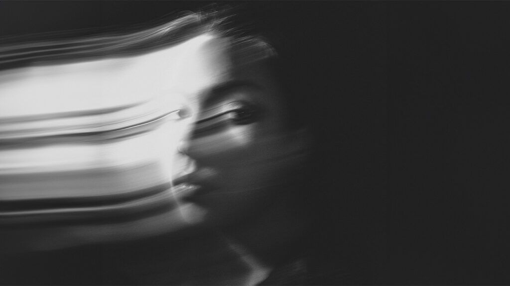 long-exposure black and white photo of woman's face in movement