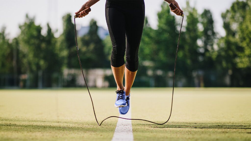 A woman jumping rope as a form of aerobic exercise in a field