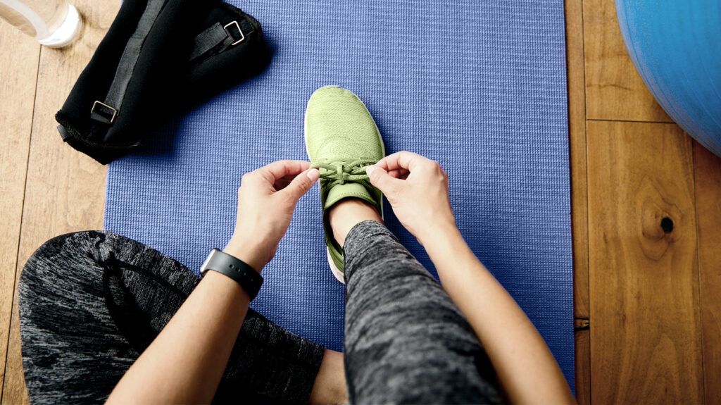 A woman tying her shoe before her workout