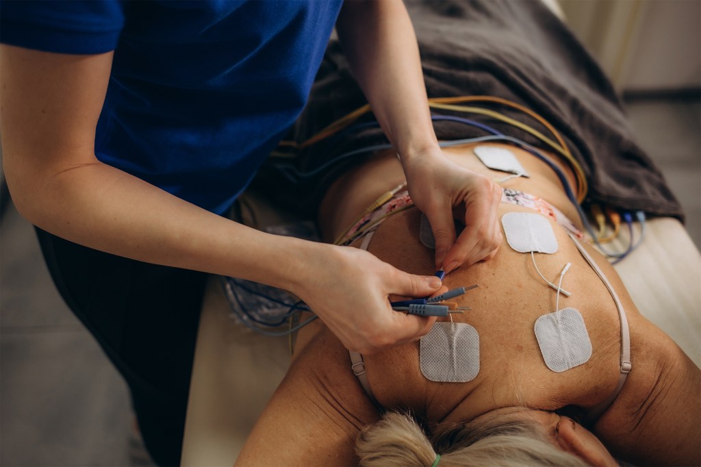 Electrical muscle stimulation can strengthen weak muscles, improve muscle function and manage pain. Here, a person has electrodes placed on their back.