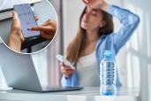 Woman sitting at desk feeling dehydrated, person setting timer on phone